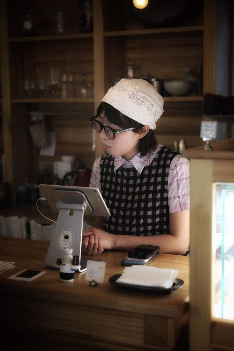 Barista using a tablet at a cafe counter